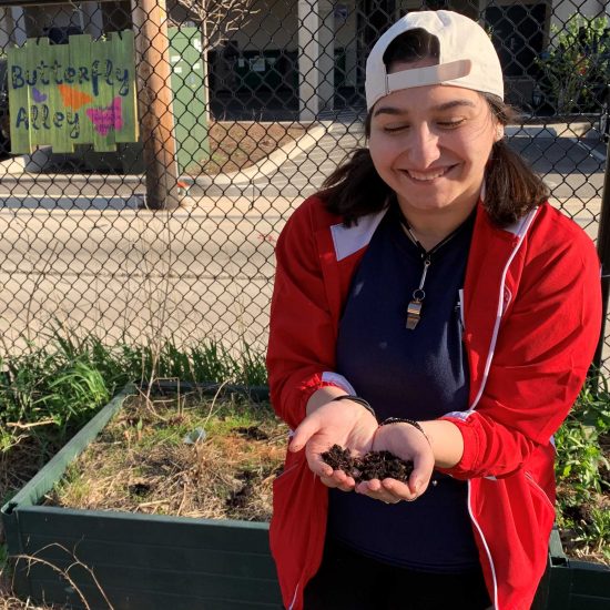 The 2019 Fall social media intern, Lizbeth Carrazco, holding some worms in UIC's butterfly garden.
